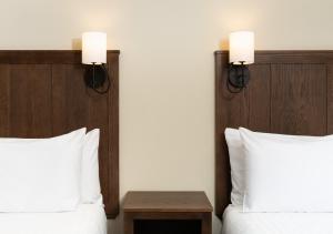 um quarto de hotel com duas camas e duas luzes na parede em Kanuga Inn & Lodging em Hendersonville