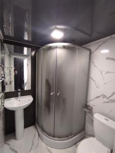 a bathroom with a shower and a toilet and a sink at Victory park apartments in Poltava +27 photos