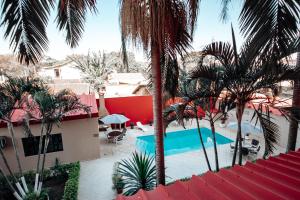 a view of a resort with a swimming pool and palm trees at Plaza Dutra Hotel in Caçapava