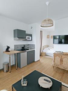 ein Wohnzimmer mit einer Küche und einem Tisch in der Unterkunft LES JARDINS avec terrasse in Amiens