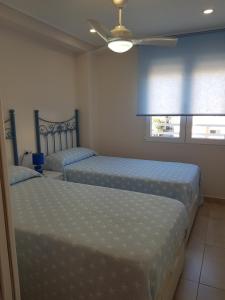 una camera da letto con due letti e un ventilatore a soffitto di APARTAMENTO 1 LINEA SAN JUAN DE ALICANTE a El Campello