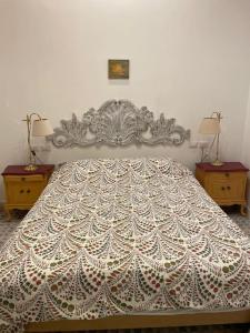 um quarto com uma grande cama branca e duas mesas em Casa Luciano al San Carlo em Nápoles