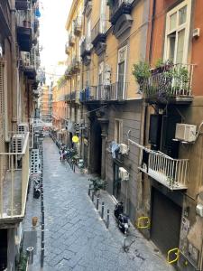 um beco estreito com edifícios e uma rua com pessoas em Casa Luciano al San Carlo em Nápoles