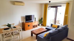 a living room with a couch and a tv at Aiolos 20 in Puerto Calero
