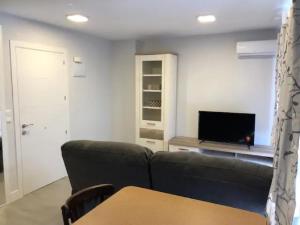 a living room with a couch and a television at Inter - Apartamento céntrico en Alcalá de Henares in Alcalá de Henares