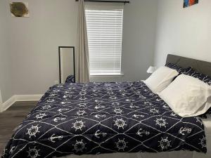 a bedroom with a bed with a black and white comforter at Cheerful 3-bedrooms with free parking on premises in Tallahassee