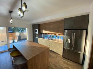 a kitchen with a stainless steel refrigerator and wooden cabinets at Vis de Apuseni in Bălceşti