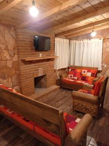 a living room with a fireplace and a tv at Cabañas el Corral del Rayo Huasca in Huasca de Ocampo
