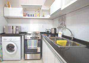 a kitchen with a sink and a washing machine at Departamentos a Pasos del Mar in Puerto Madryn