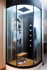 a glass shower with a bench in a room at Hotel Crans Montana in San Carlos de Bariloche