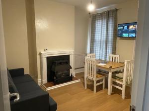 a living room with a table and a fireplace at Rooms In A Victorian Comfortable 4-bedroom house in Milton Keynes Rooms Not En-suites in Wolverton