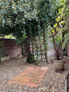 a garden with a brick wall and a brick walkway at Rooms In A Victorian Comfortable 4-bedroom house in Milton Keynes Rooms Not En-suites in Wolverton