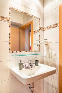 ein Bad mit einem Waschbecken und einem Spiegel in der Unterkunft Öko-Appartements Fallhaus in Forstau