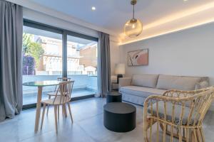 ein Wohnzimmer mit einem Sofa und einem Tisch in der Unterkunft Livemalaga Pedregalejo Suites in Málaga