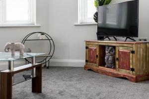 a living room with a flat screen tv on a wooden entertainment center at Lima Apartments Ltd-4 Beds-Large property -Long Stay Deal-Business-Parking in Bournemouth +10 photos