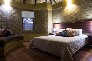 una camera con un grande letto in un muro di mattoni di Chalets Sol Muisca RNT85322 a Villa de Leyva