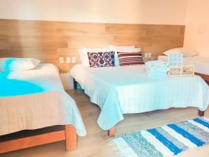 um quarto com duas camas com almofadas em Pousada Mangue Seco em Itaúnas