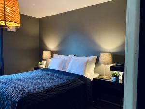 - une chambre avec un lit bleu et deux lampes dans l'établissement Idyllic Villa Unikko With Jacuzzi And Sauna, à Pori