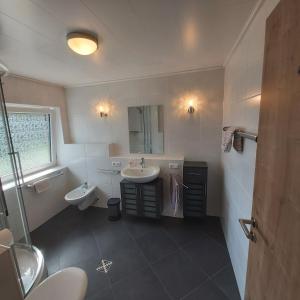 a bathroom with two sinks and a mirror at Gabis Ferienwohnung Bendingbostel in Bendingbostel