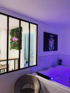 ブザンソンにあるL’appart[é] BLACK superbe appartement pop !の紫色のバスルーム(バスタブ付)、大きな窓が備わります。