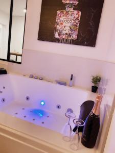 a bath tub with vases and bottles on it at L’appart[é] BLACK superbe appartement pop ! in Besançon