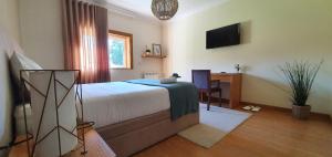 sypialnia z łóżkiem, biurkiem i telewizorem w obiekcie Villam Natura & Spa w mieście Vila Nova de Famalicão