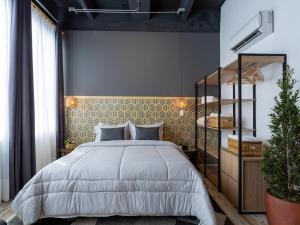 Hotel Lexum Estadio في ميديلين: غرفة نوم مع سرير كبير ورف
