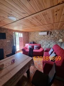 una sala de estar con muebles de color rojo y techo de madera. en Casa Rural Los Cipreses en Benaoján