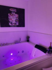 a bath tub with purple lighting in a bathroom at L’appart[é] BLACK superbe appartement pop ! in Besançon