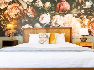 a bedroom with a floral wallpaper with a bed at Fleur Noire Hotel in Palm Springs