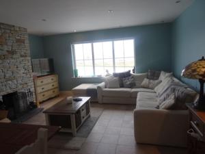 uma sala de estar com um sofá e uma lareira em Everest Lodge Guest House em Dunfanaghy