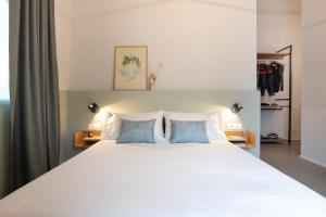 a bedroom with a large bed with two blue pillows at Camere d'Aria in Locana