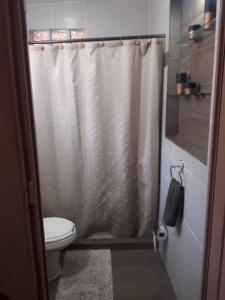 a bathroom with a white shower curtain and a toilet at Villa Paraiso in Emiliano Zapata