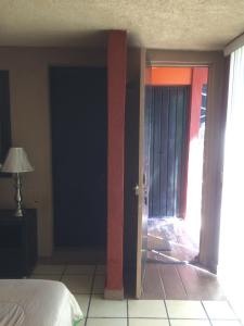 Villa Paraiso في Emiliano Zapata: غرفة نوم مع باب مفتوح على غرفة بسرير