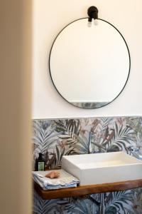 a bathroom mirror on a shelf with a sink at Il Sestante vista mare in Gaeta