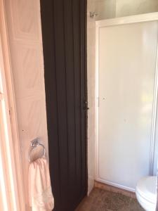 Baño con puerta negra y toalla en Villa Paraiso en Emiliano Zapata