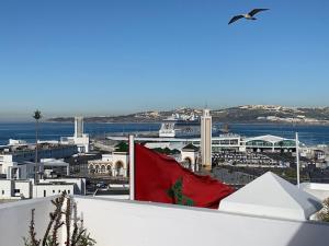 a bird flying over a city with a red flag at Tanger *Maison avec terrasse et vue sur la mer * in Tangier