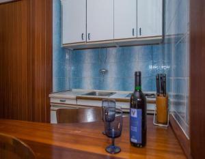 uma cozinha com uma mesa de madeira com duas garrafas de vinho em Apartments and rooms Anita - parking em Sumartin