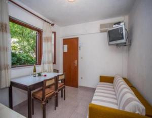 een woonkamer met een bank en een tafel bij Apartments and rooms Anita - parking in Sumartin