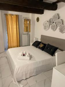 Un dormitorio con una cama blanca con dos animales de peluche. en Il nido degli angeli en Bolonia
