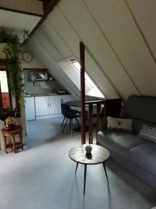 ein Wohnzimmer mit einem Sofa und einem Tisch in der Unterkunft Romantic Studio Vacances in Labaroche