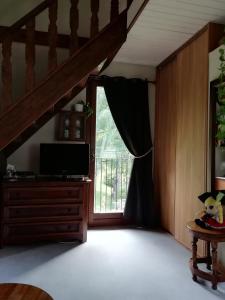 a living room with a tv and a window at Romantic Studio Vacances in Labaroche