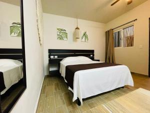 a hotel room with two beds and a mirror at Corazon de Tulum in Tulum