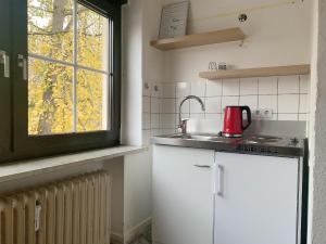eine Küche mit einer Spüle und einem roten Gerät in der Unterkunft Monteurwohnung Mönchengladbach Geroweiher in Mönchengladbach
