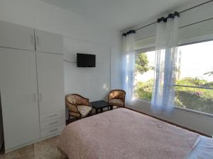 a bedroom with a bed and a tv and a window at PISO PLAYA ALCOSSEBRE in Alcossebre