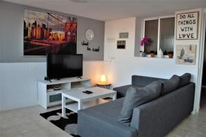 a living room with a couch and a tv at Apartamento a tan solo 2 minutos de la playa in Puerto del Rosario