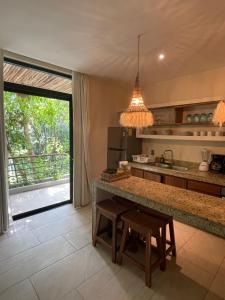 a kitchen with a island with a table and a counter top at Jungle View 2bed 2bath Condo/ Wi-Fi/ Pool/ Gym in Tulum