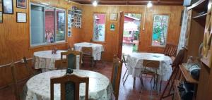 a restaurant with white tables and chairs and windows at El Rincon de los Poetas in Nueva Imperial