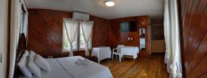 Schlafzimmer mit einem Bett, einem Tisch und Stühlen in der Unterkunft Coral View Beach Resort in Utila