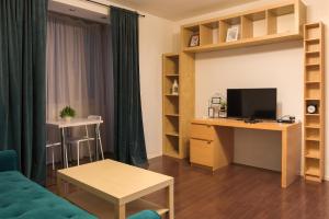 un salon avec un canapé et un bureau avec une télévision dans l'établissement Ultracentral Apartment - "Saint Anthony" Church & Old Town View, à Bucarest